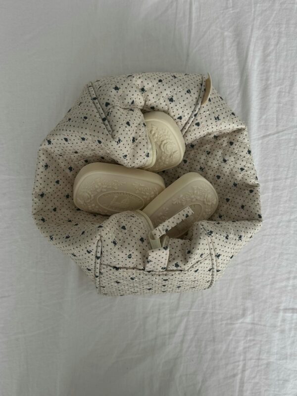 Top view of soft baby booties in a stylish fabric basket.